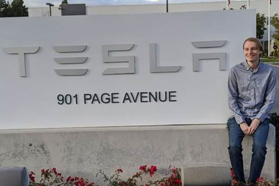 Joel Austin in front of Tesla sign