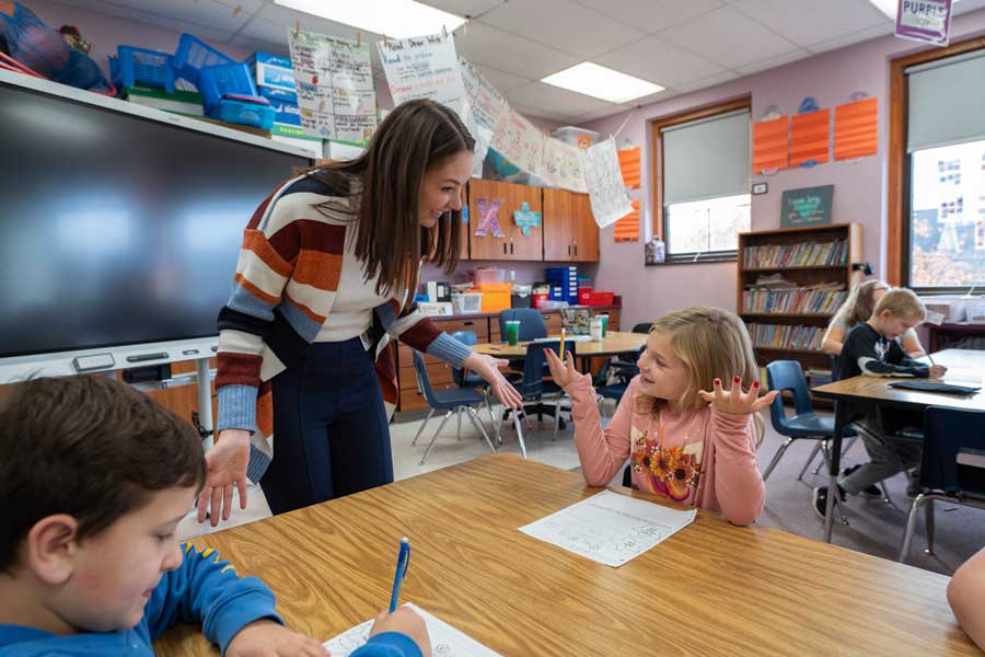 A student teacher talking to a child in class