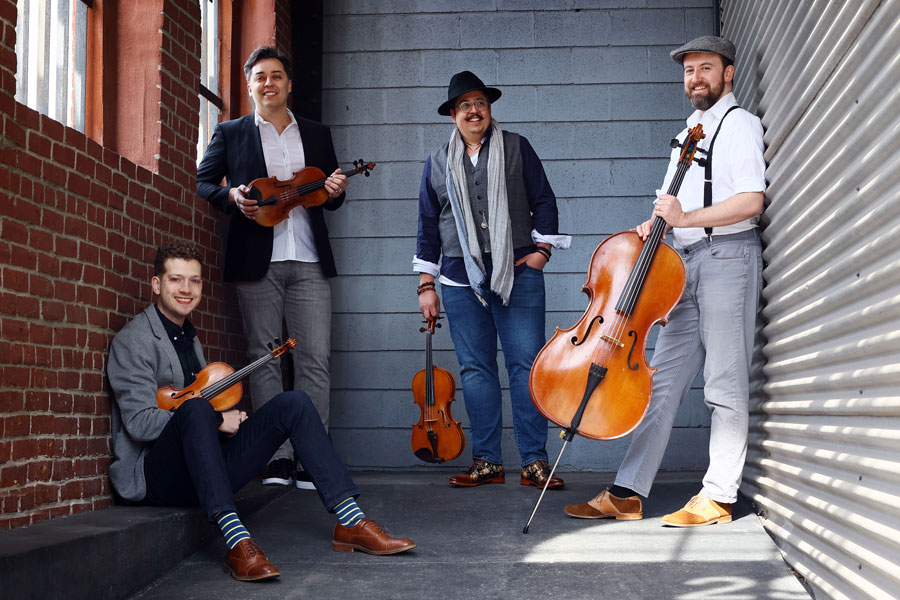 BEO string quartet in a hallway with brick walls