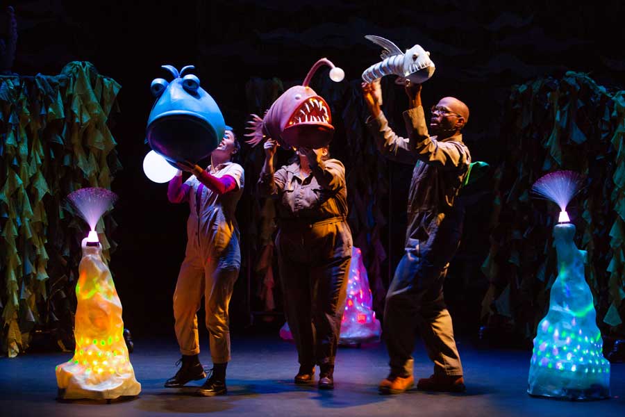 TheaterWorks group holding fish puppets on stage