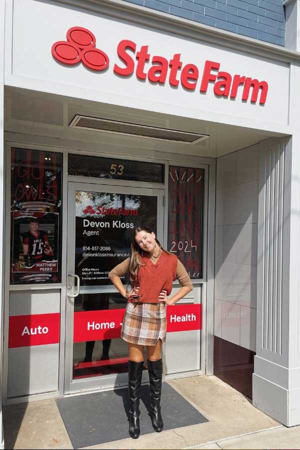 Maeve standing in front of the doors to a State Farm insurance building