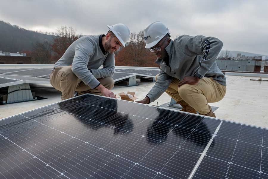 Matt Kropf and Allee Williams working on the solar panels on the roof of the Duke building