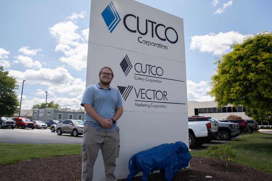 Billy standing in front of the Cutco sign 